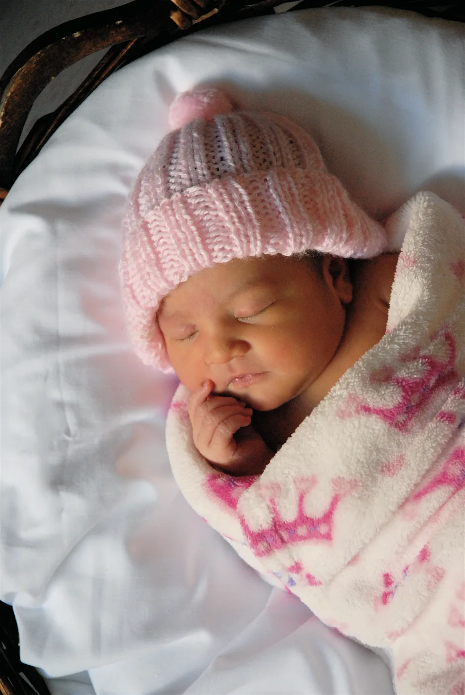 Newborn Celeste in a pink knit hat.