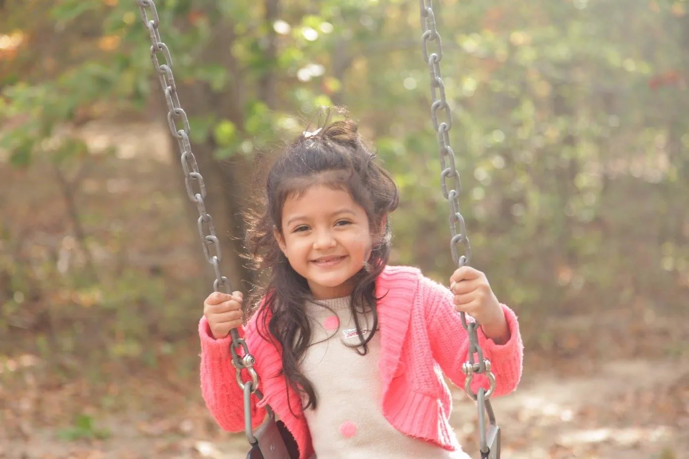 Little Celeste smiling on a swing.