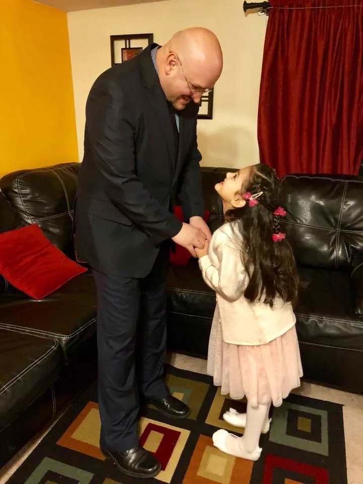Little Celeste holding her dad’s hands at home.
