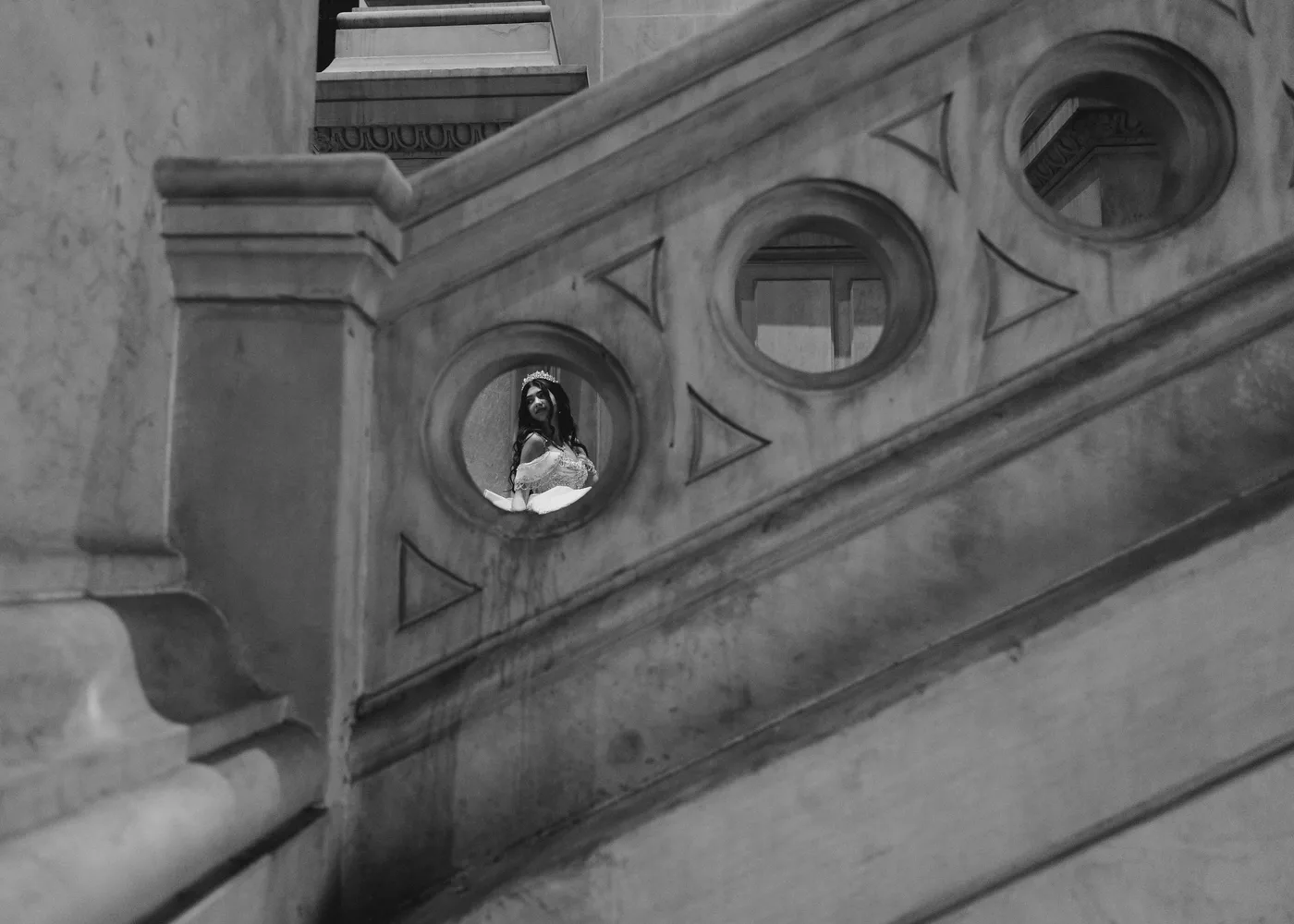Black and white photo of Celeste looking out from a round window.